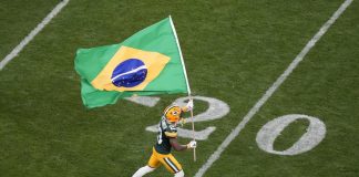 Jogador do Green Bay Packers entra na Arena Corinthians com a bandeira do Brasil