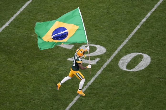 Jogador do Green Bay Packers entra na Arena Corinthians com a bandeira do Brasil