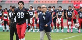 Hosomi caminha para o cointoss em jogo comemorativo de Kobe Ravens em outubro de 2025. (Foto: Kobe University)